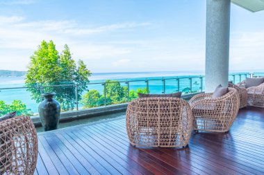 veranda sandalye ve masa deniz görünümü arka plan ile
