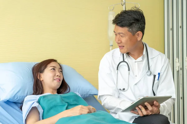 Asiatique médecin principal assis sur le lit d'hôpital et de discuter avec — Photo