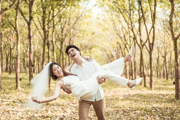 Счастливая азиатская пара влюблена в древесную арку — стоковое фото