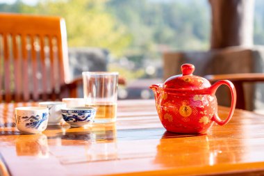 çaydanlık ve bardak sabah güneş ışığı ile masaya