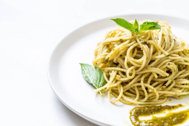 Spagetti pesto sos, zeytin yağı ve fesleğen yaprakları ile.