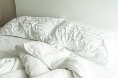yastık yatak ve yatak odasında kırışıklık dağınık battaniye ile