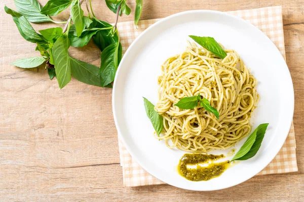 Spaghetti z sosem pesto, oliwa z oliwek i liści bazylii. — Zdjęcie stockowe