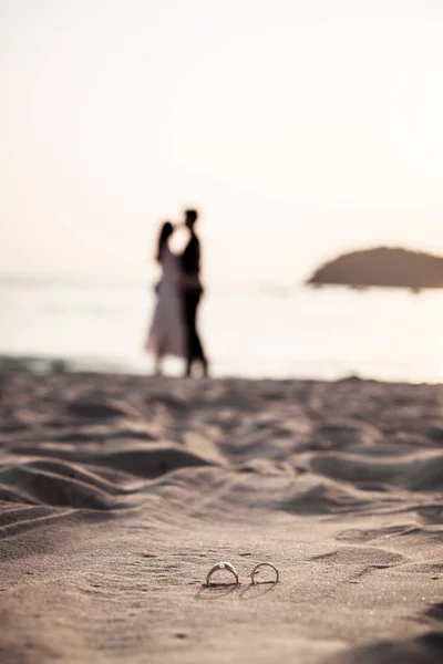 Ringen op strand met bruid en bruidegom op achtergrond — Stockfoto