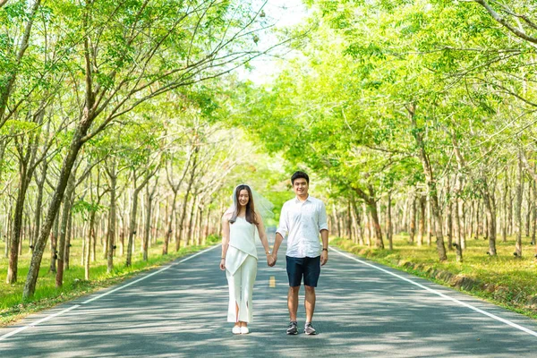 Gelukkige Aziatische paar verliefd op weg met boom boog — Stockfoto