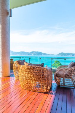 veranda sandalye ve masa deniz görünümü arka plan ile