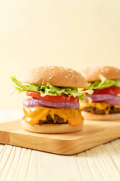 Hambúrguer de carne fresca saborosa com queijo e batatas fritas — Fotografia de Stock