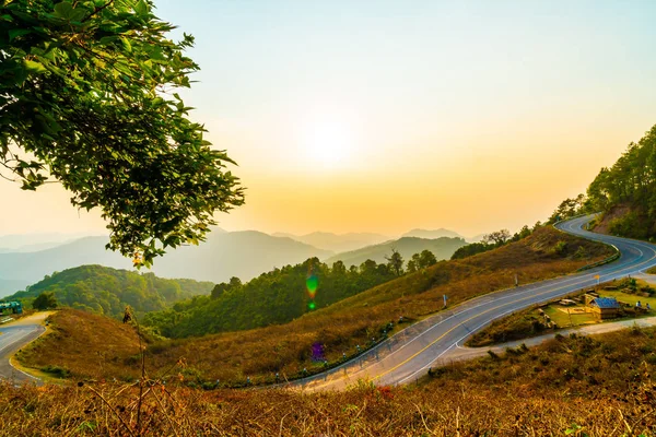 stock image beautiful sunset sky with layer mountain and road