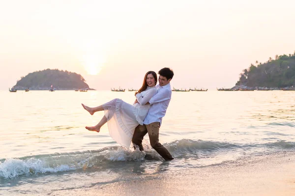 Joyeux couple voyageant en lune de miel sur une plage de sable tropical à su — Photo