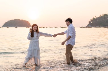 Mutlu çift balayı gidiş tropikal kum plajı üzerinde su içinde seyahat.