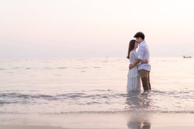 Mutlu çift balayı gidiş tropikal kum plajı üzerinde su içinde seyahat.