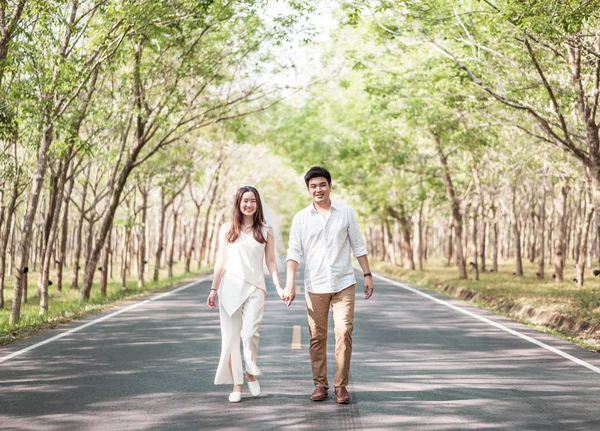 Gelukkige Aziatische paar verliefd op weg met boom boog — Stockfoto