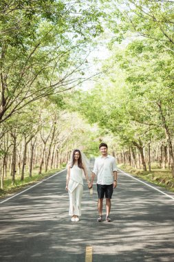 Ağaç arch ile yolda aşık mutlu Asya çift