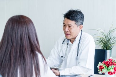 Asyalı doktor ve hasta görüşüyorlar