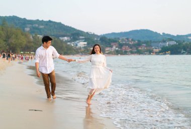 Mutlu çift balayı gidiş tropikal kum plajı üzerinde su içinde seyahat.