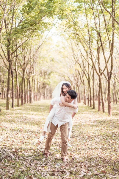 Happy Asian couple in love with tree arch — Stock Photo, Image