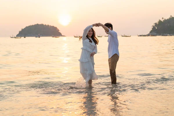 Joyeux couple voyageant en lune de miel sur une plage de sable tropical à su — Photo