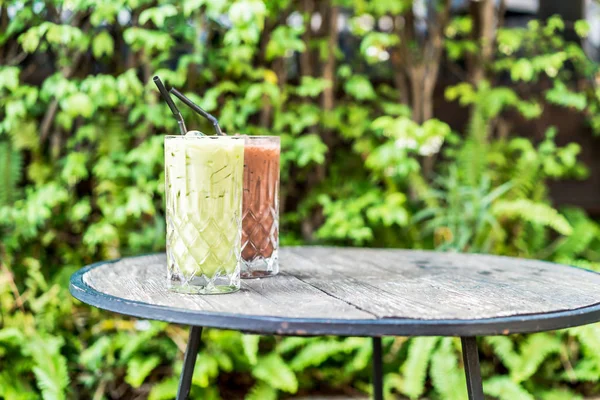 Chá verde matcha gelado e vidro de chocolate na mesa — Fotografia de Stock