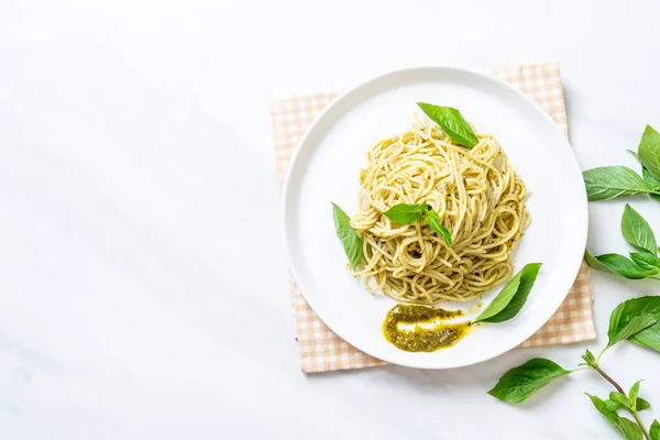 Spaghetti with pesto sauce, olive oil and basil leaves. — Stock Photo, Image