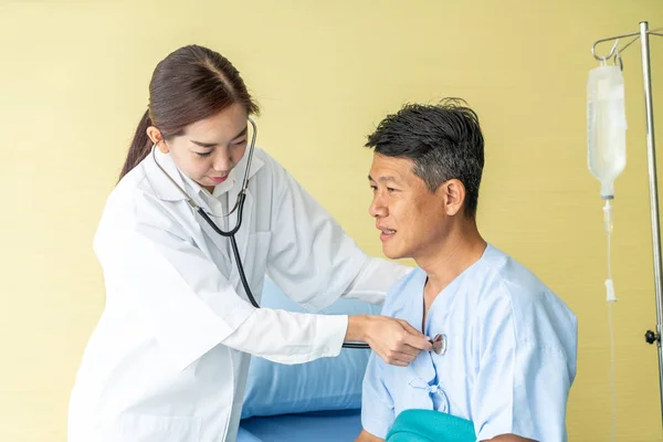 Asijské starší pacient na nemocniční posteli diskutovat s ženské doct — Stock fotografie