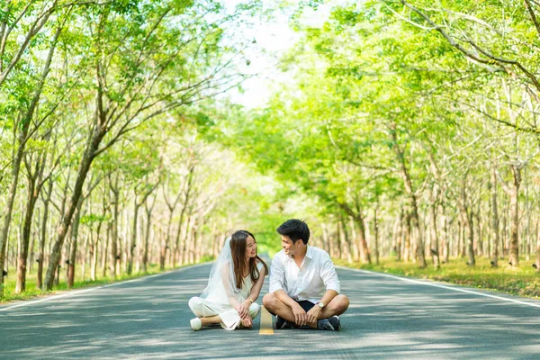 Gelukkige Aziatische paar verliefd op weg met boom boog — Stockfoto