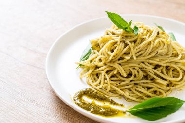 Spagetti pesto sos, zeytin yağı ve fesleğen yaprakları ile.