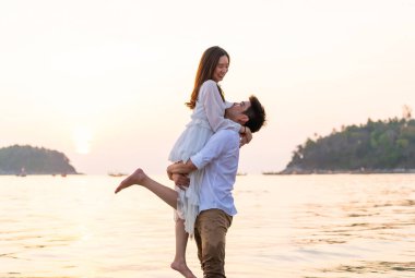 Mutlu çift balayı gidiş tropikal kum plajı üzerinde su içinde seyahat.