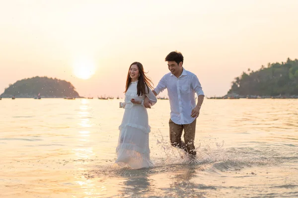 Счастливая пара собирается медовый месяц путешествовать по тропическому песчаному пляжу в су — стоковое фото