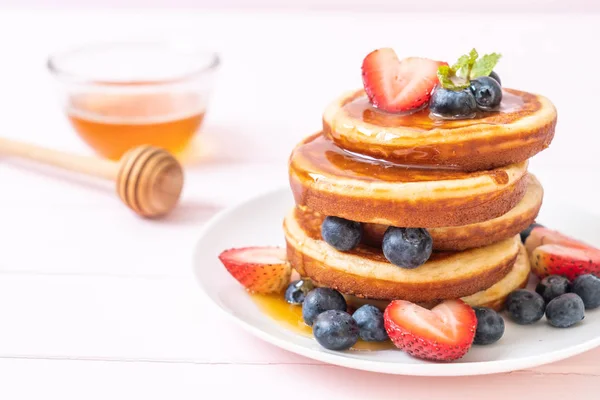 Pfannkuchen mit frischen Blaubeeren, frischen Erdbeeren und Honig — Stockfoto