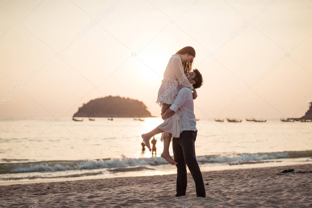Happy couple going honeymoon travel on tropical sand beach in su