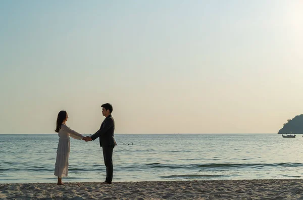 Happy couple going honeymoon travel on tropical sand beach in su