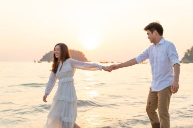 Mutlu çift balayı gidiş tropikal kum plajı üzerinde su içinde seyahat.