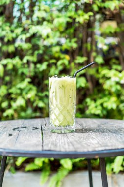 buzlu matcha yeşil çay bardağı masanın üzerine