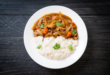 Japanese curry rice with sliced pork, carrot and onions clipart