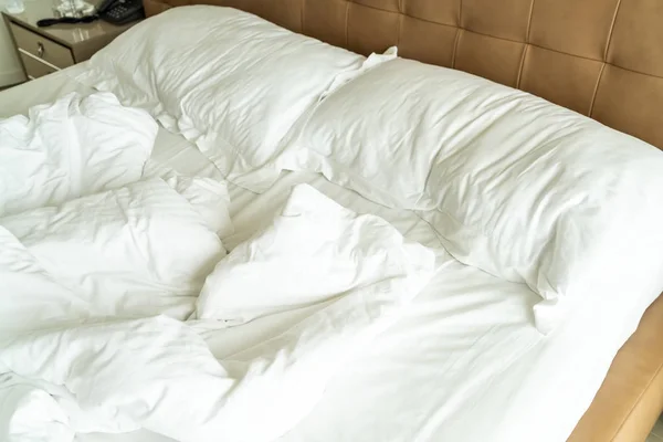 白い枕と毛布が付いている乱雑なベッド — ストック写真