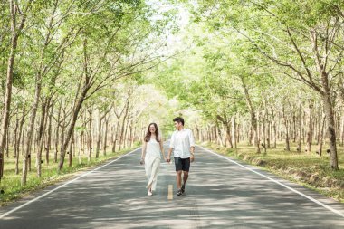 Ağaç arch ile yolda aşık mutlu Asya çift