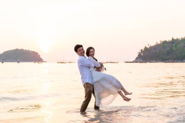 Mutlu çift balayı gidiş tropikal kum plajı üzerinde su içinde seyahat.