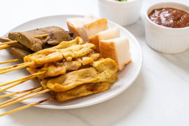 Fıstık sosu ve turşu ile domuz Satay cucumbe olan