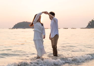 Mutlu çift balayı gidiş tropikal kum plajı üzerinde su içinde seyahat.