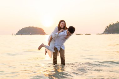 Mutlu çift balayı gidiş tropikal kum plajı üzerinde su içinde seyahat.