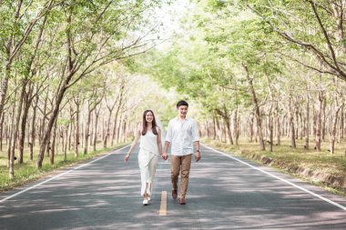 Ağaç arch ile yolda aşık mutlu Asya çift