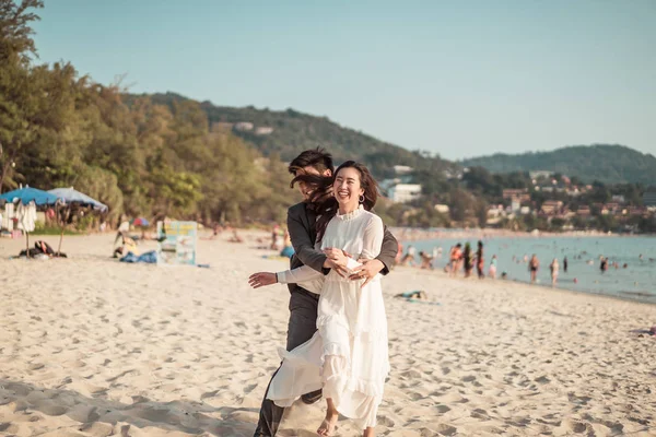 Joyeux couple voyageant en lune de miel sur une plage de sable tropical à su — Photo