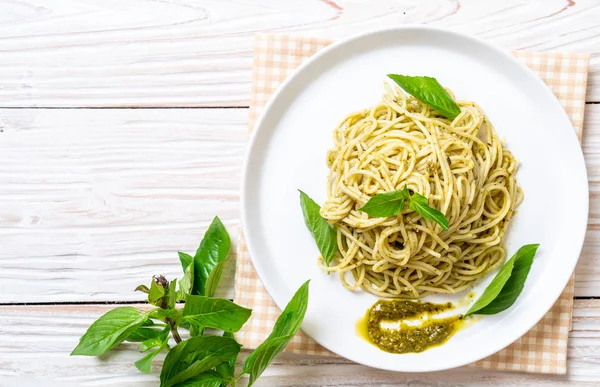 Spaghetti with pesto sauce, olive oil and basil leaves. — Stock Photo, Image