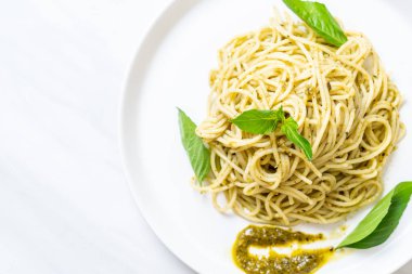 Spagetti pesto sos, zeytin yağı ve fesleğen yaprakları ile.