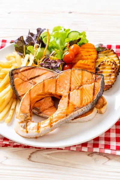 Filet de steak de saumon grillé aux légumes et frites — Photo