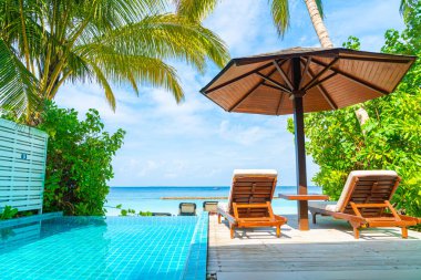 Maldivler yüzme havuzu ve deniz arka plan ile plaj sandalyesi