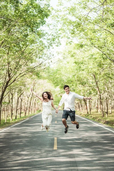 Gelukkige Aziatische paar verliefd op weg met boom boog — Stockfoto