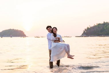 Mutlu çift balayı gidiş tropikal kum plajı üzerinde su içinde seyahat.