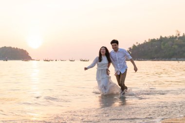 Mutlu çift balayı gidiş tropikal kum plajı üzerinde su içinde seyahat.