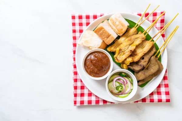 Satay de cerdo con su salsa de maní y encurtidos que son cucumbe —  Fotos de Stock